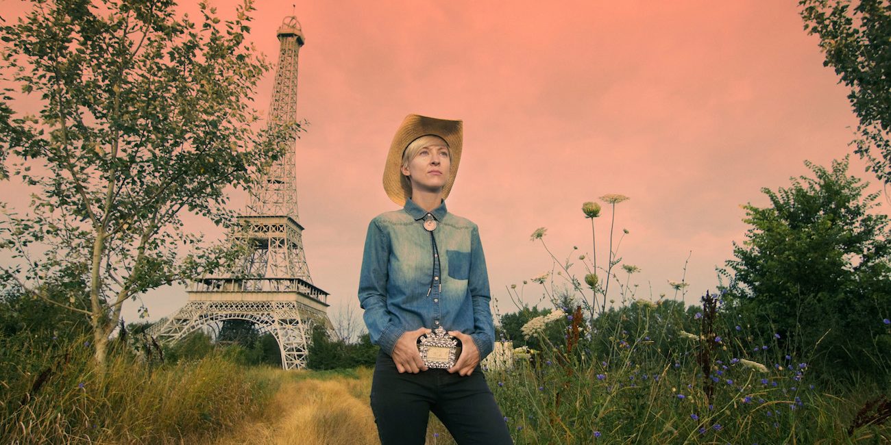 Livia Ungur Eiffel-tornin pienoismallin edessä Hotel Dallas -dokumenttielokuvassa.